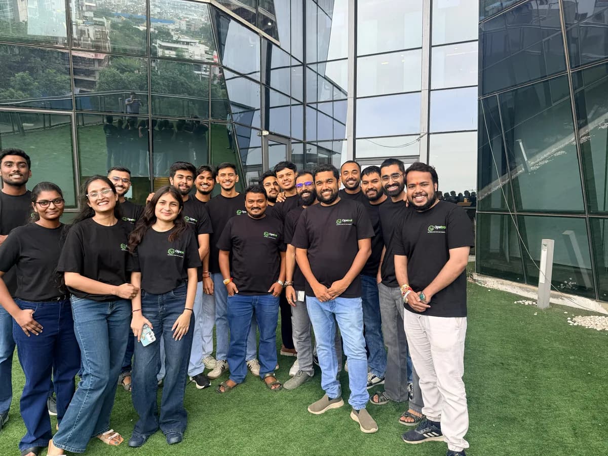 Opstral team members laughing together in branded t-shirts outside the office