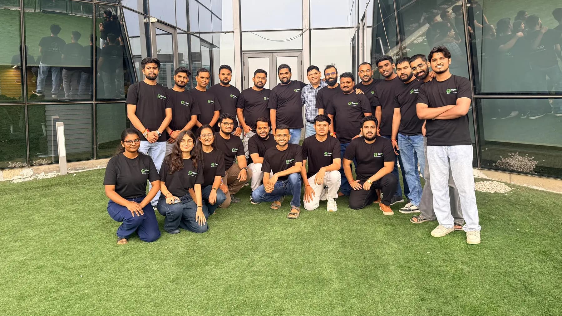 The Opstral team in branded t-shirts outside the office